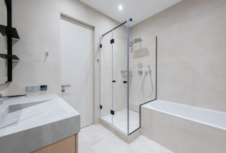 A contemporary bathroom featuring a sink ,bathtub and a beautiful glass shower bath