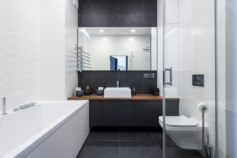 A contemporary bathroom featuring a toilet, sink, and bathtub