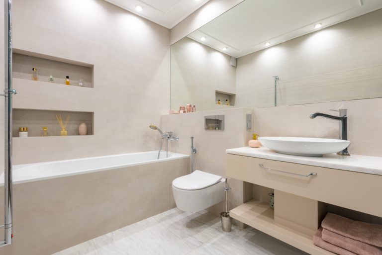 A contemporary bathroom featuring a toilet, sink, and bathtub